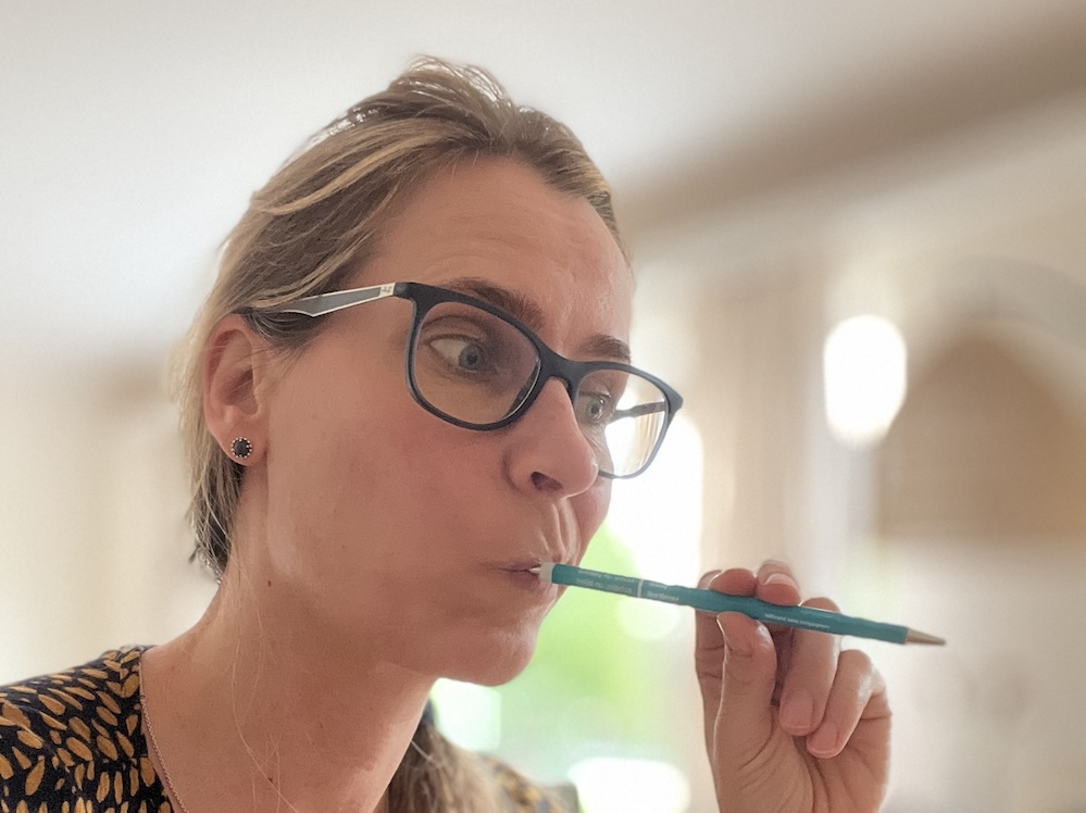 Stephanie nachdenklich mit blauen Stift im Mund